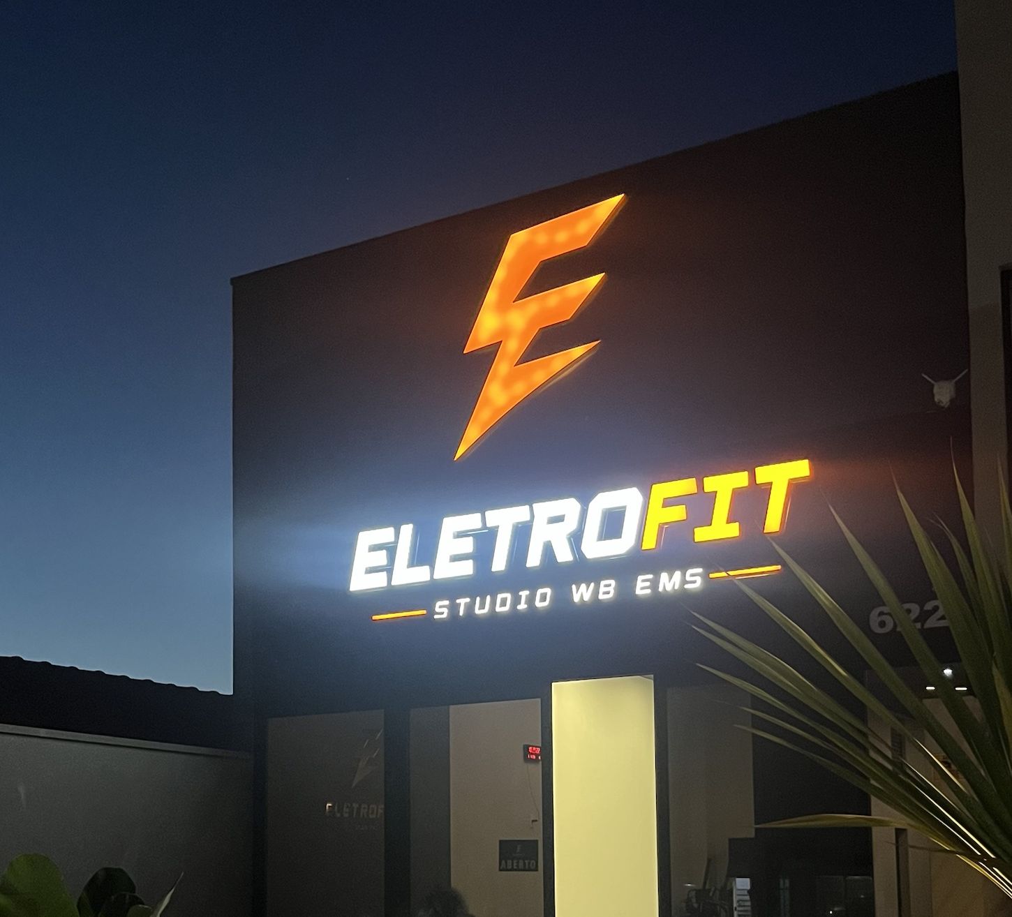 Fachada do Eletrofit Estúdio à noite, com o letreiro aceso